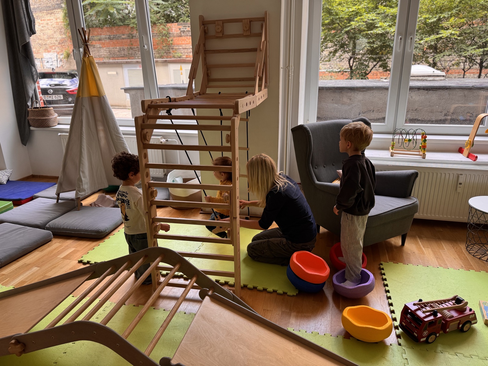 Kinder spielen mit einer Betreuungsperson im juggleHUB